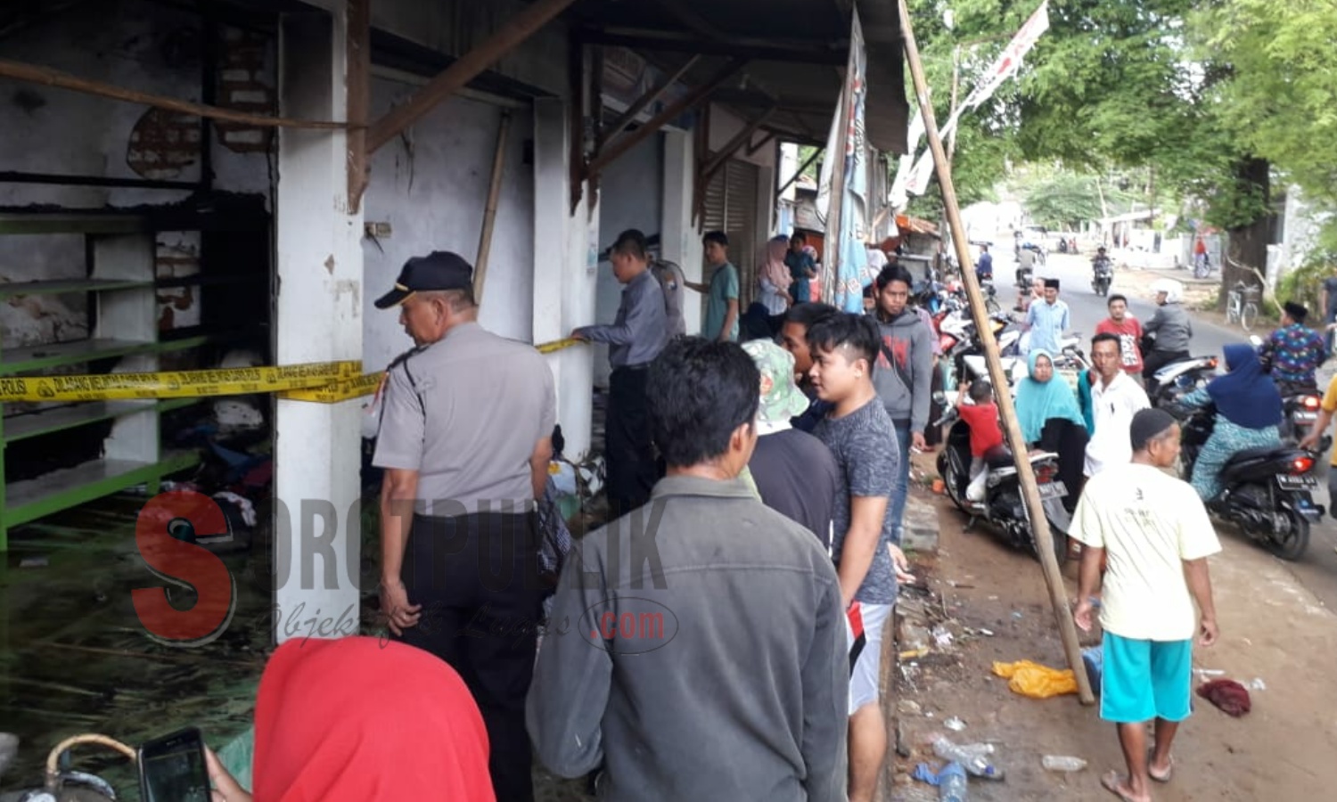 Petugas kepolisian memasang police line di toko Syahril Laundry di Jalan Raya Lenteng, Sumenep yang terbakar akibat kebocoran tabung LPG. (Foto: Ist/SorotPublik)