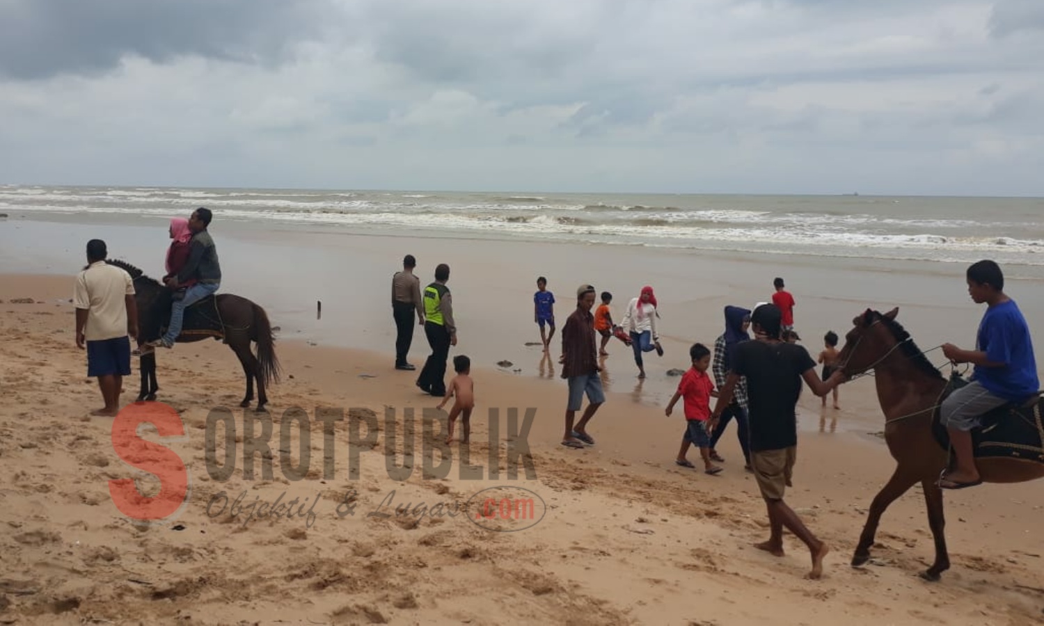 Dua petugas Polsek Dasuk di antara para pengunjung saat melakukan pengamanan di lokasi wisata Pantai Slopeng Sumenep. (Foto: Heri/SorotPublik)