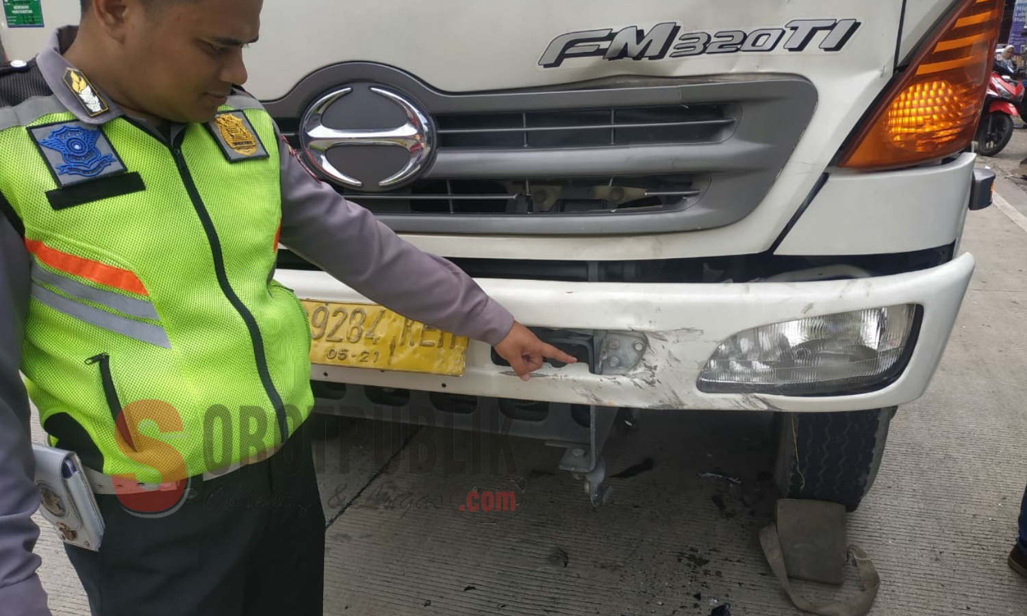 Petugas Laka Lantas menunjukkan lecet di bagian depan truk tangki pasca menabrak sepeda motor di Jalan Raya HE Sukma KM 16, Kampung Caringin, Bogor. (Foto: Asep/SorotPublik)