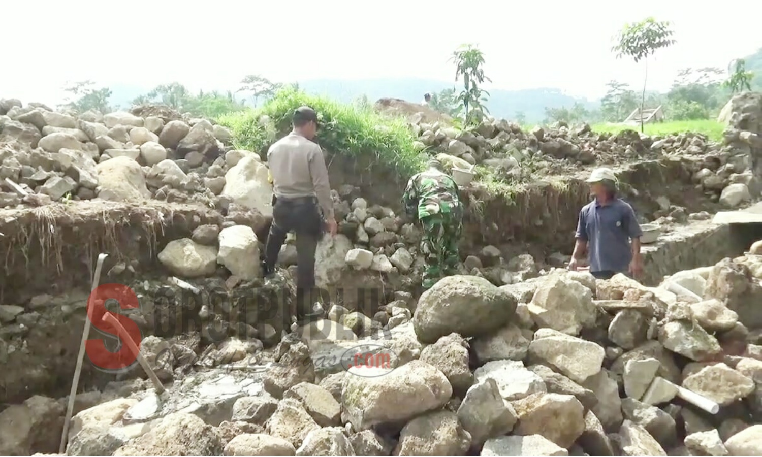 Terlihat warga setempat dibantu TNI dan Polri sedang berupaya mengangkat bebatuan pasca ambruknya senderan di Desa Kumbung, Kecamatan Rajagaluh, Kabupaten Majalengka. (Foto: Sigit/SorotPublik)