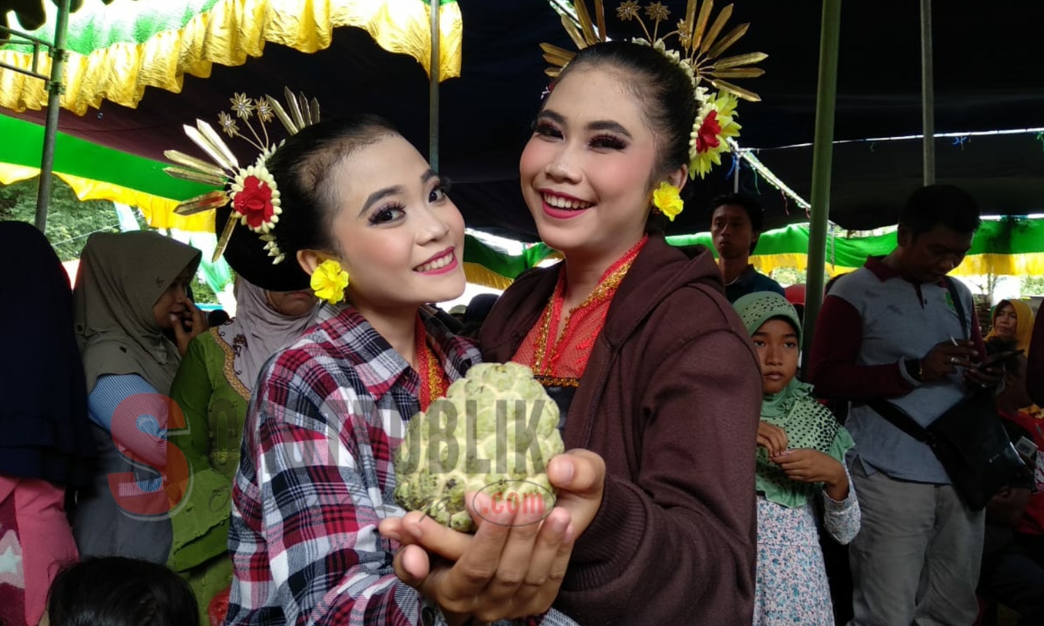 Pengunjung di acara Festival Srikaya 2019 di Sumenep berpose sambil memegang buah Srikaya. (Foto: Hairul/SorotPublik)