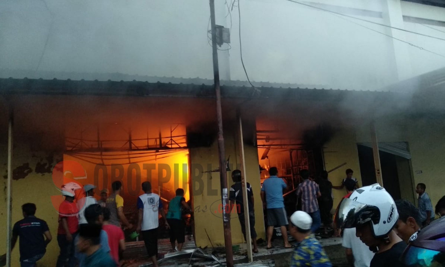 Petugas bersama warga saat berusaha memadamkan api pada kios sebalah barat Blok A yang terbakar di Pasar Anom Baru Sumenep, Madura. (Foto: Hairul/SorotPublik)