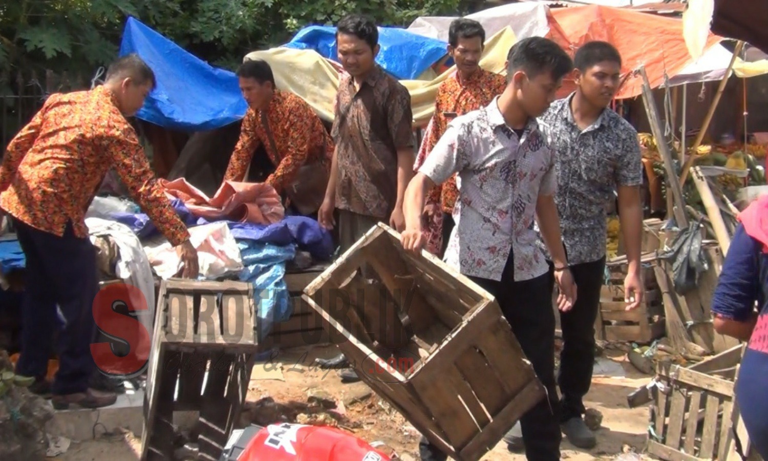 Petugas  Disperindag Sumenep membantu pedagang menata lapak yang menganggu jalan di Pasar Anom Baru Sumenep. (Foto: Hairul/SorotPublik)