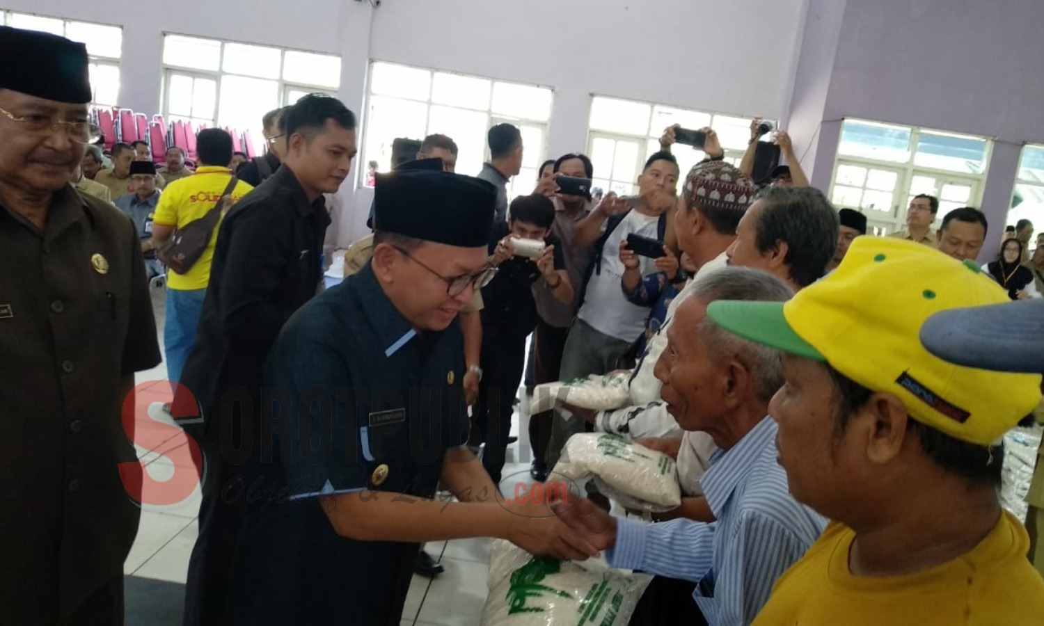 Bupati Sumenep, KH A. Busyro Karim saat membagikan Zakat Fitrah para ASN di aula KORPRI Sumenep. (Foto: Hairul/SorotPublik)