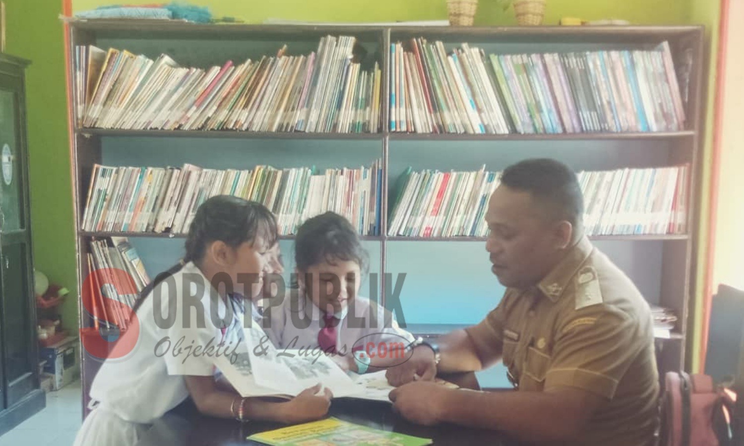 Kepala Desa Batu Boy, Imran Wamnebo saat mendampingi anak-anak di Perpustakaan Desa setempat. (Foto: Adam S/SorotPublik)